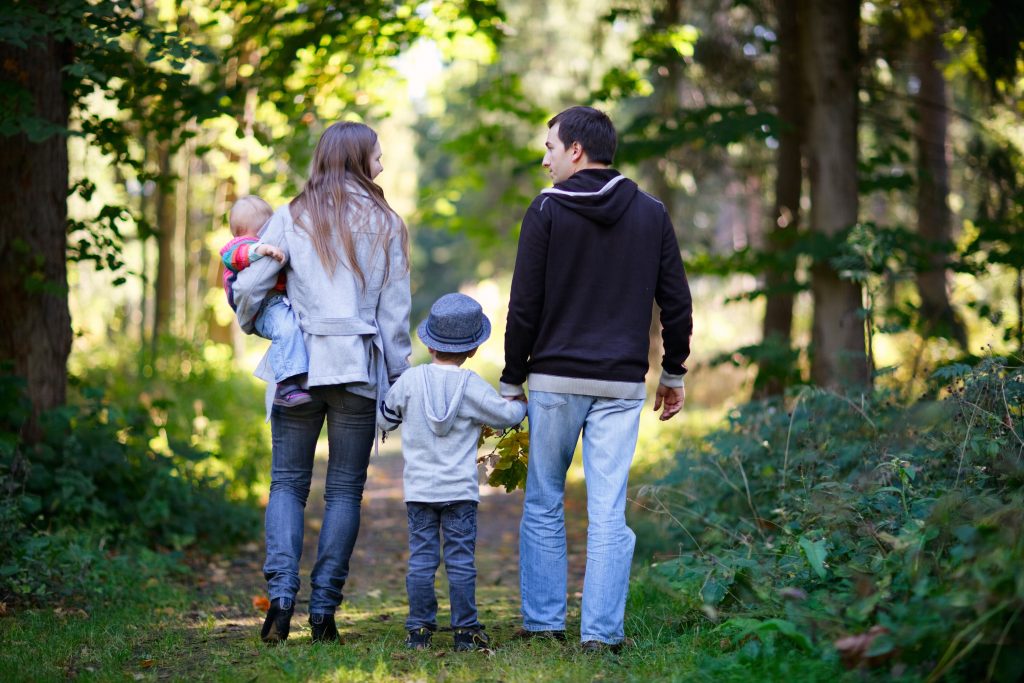 Familj på promenad i skogen